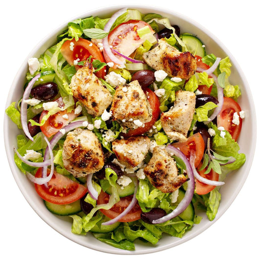 A vibrant and bold salad with cheese grated on top of tomatoes, onions, beans, and lettuce.