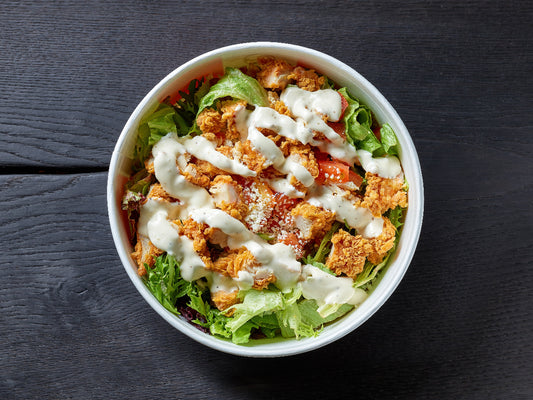 chicken caesar salad on a table presented with chicken shots
