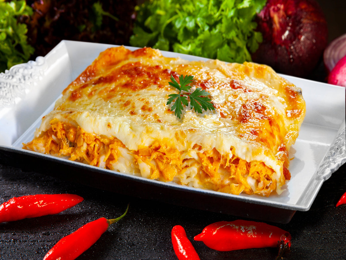Spicy chicken lasagna with red spices served on a platter