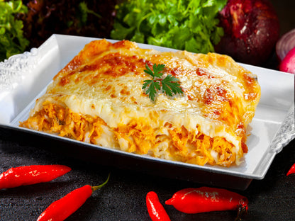 Spicy chicken lasagna with red spices served on a platter
