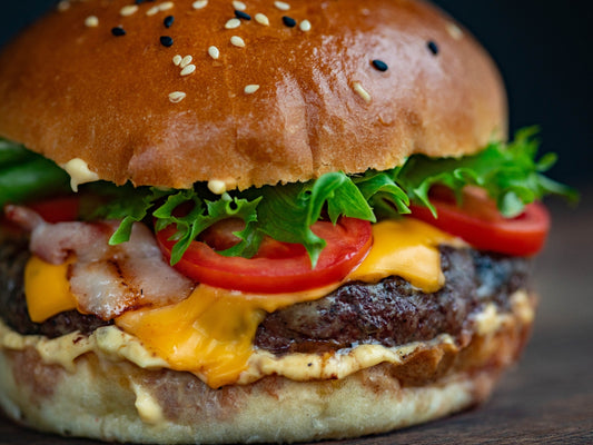 Juicy smoky grilled beef burger with cheese and tomatoes, and lettuce