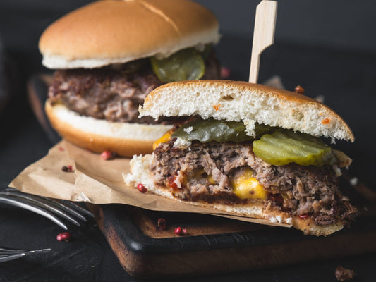 Beef burger stuffed with cheese and layered with pickles and sauces.